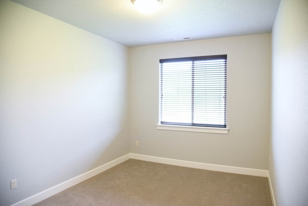 a room with a window and white walls and carpet