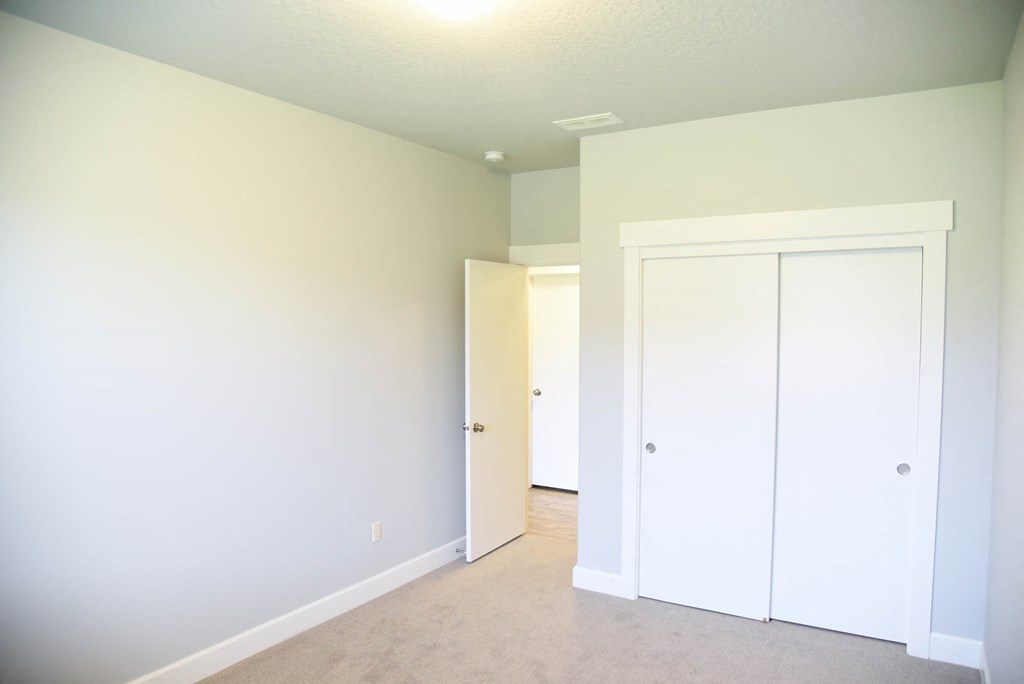 a bedroom with white walls and a closet