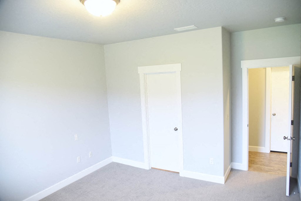 an empty room with white walls and a door to a closet