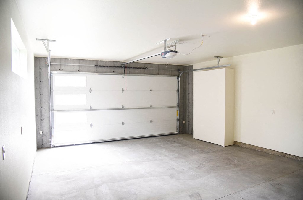 an empty garage with a white wall and a white garage door