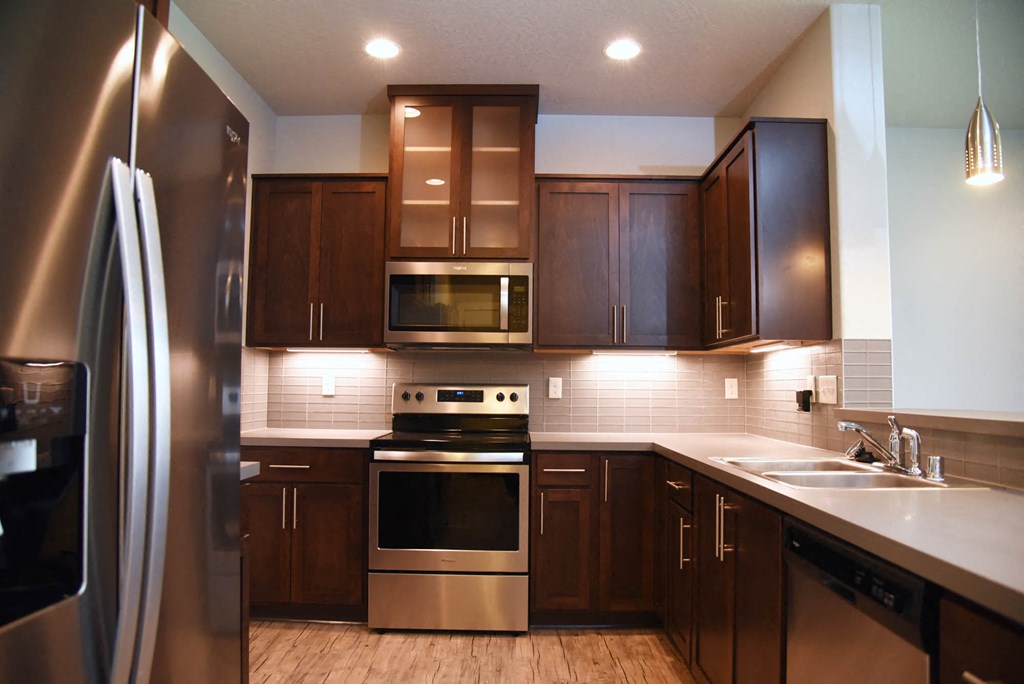 a kitchen with stainless steel appliances and wooden cabinets