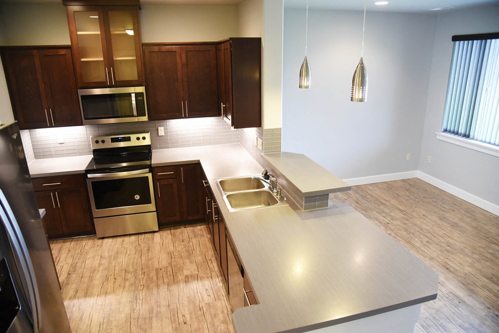 a large kitchen with stainless steel appliances and wooden floors