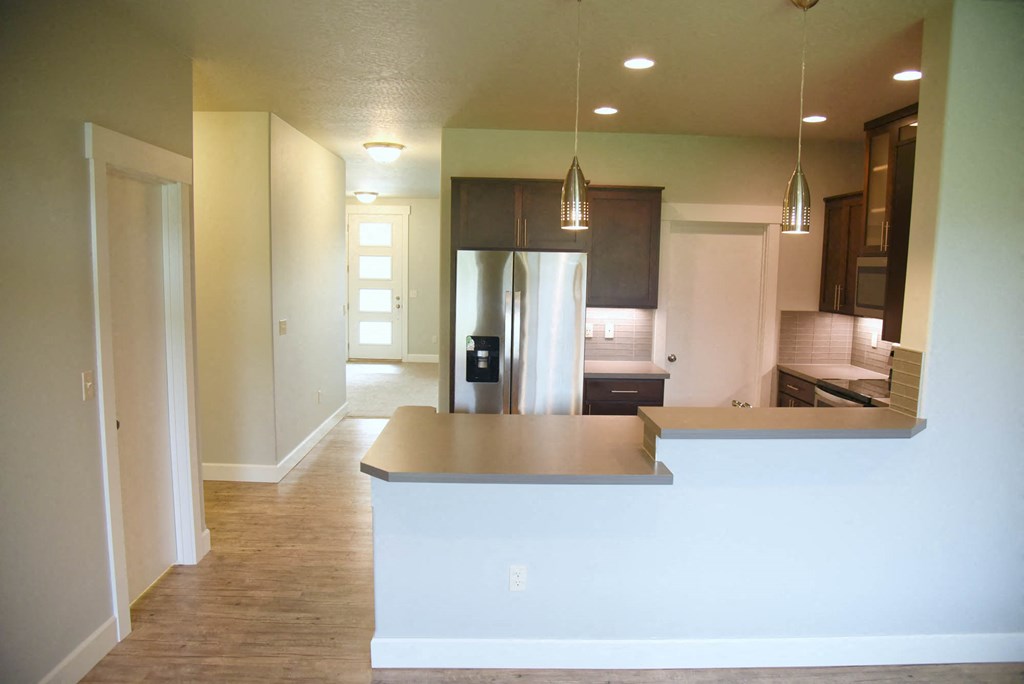 an empty kitchen with a white counter top