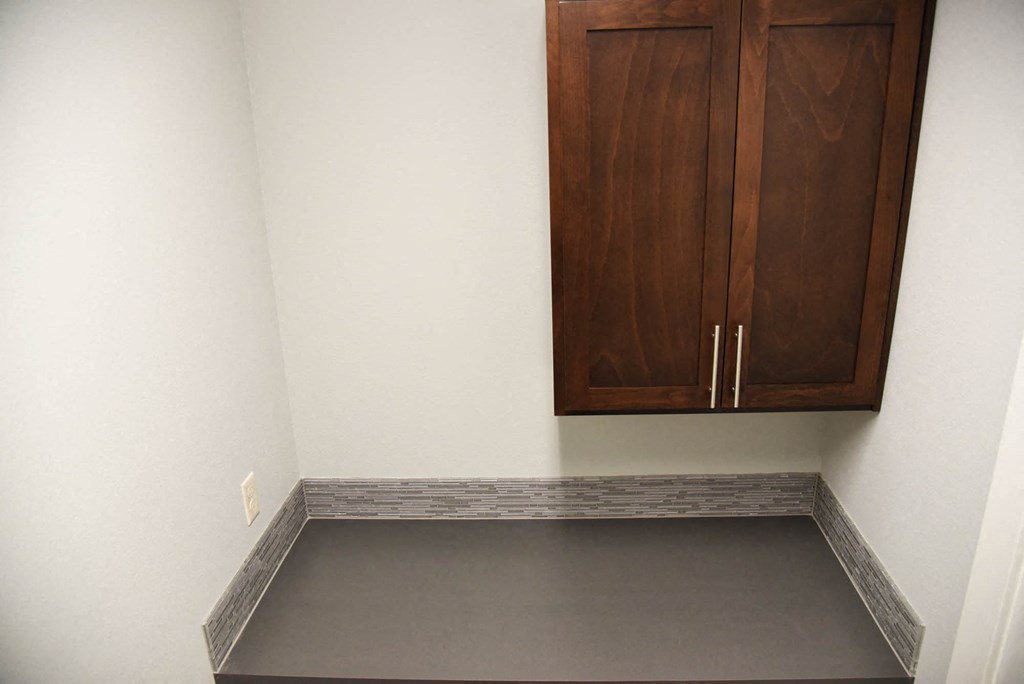 an empty room with a cabinet on the wall and a gray floor