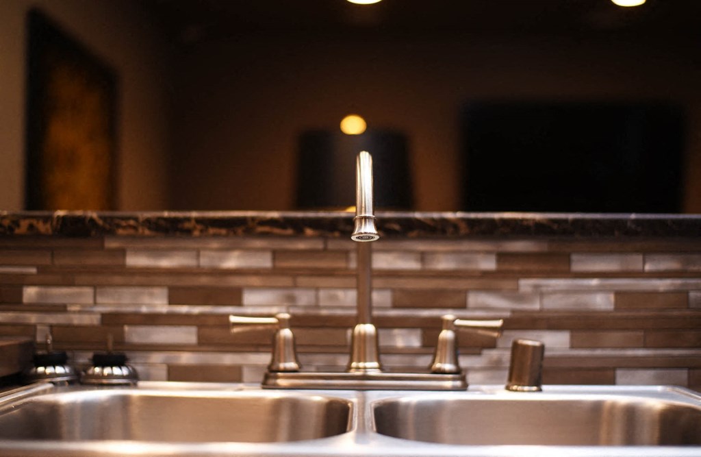 a stainless steel sink with a faucet in a bathroom