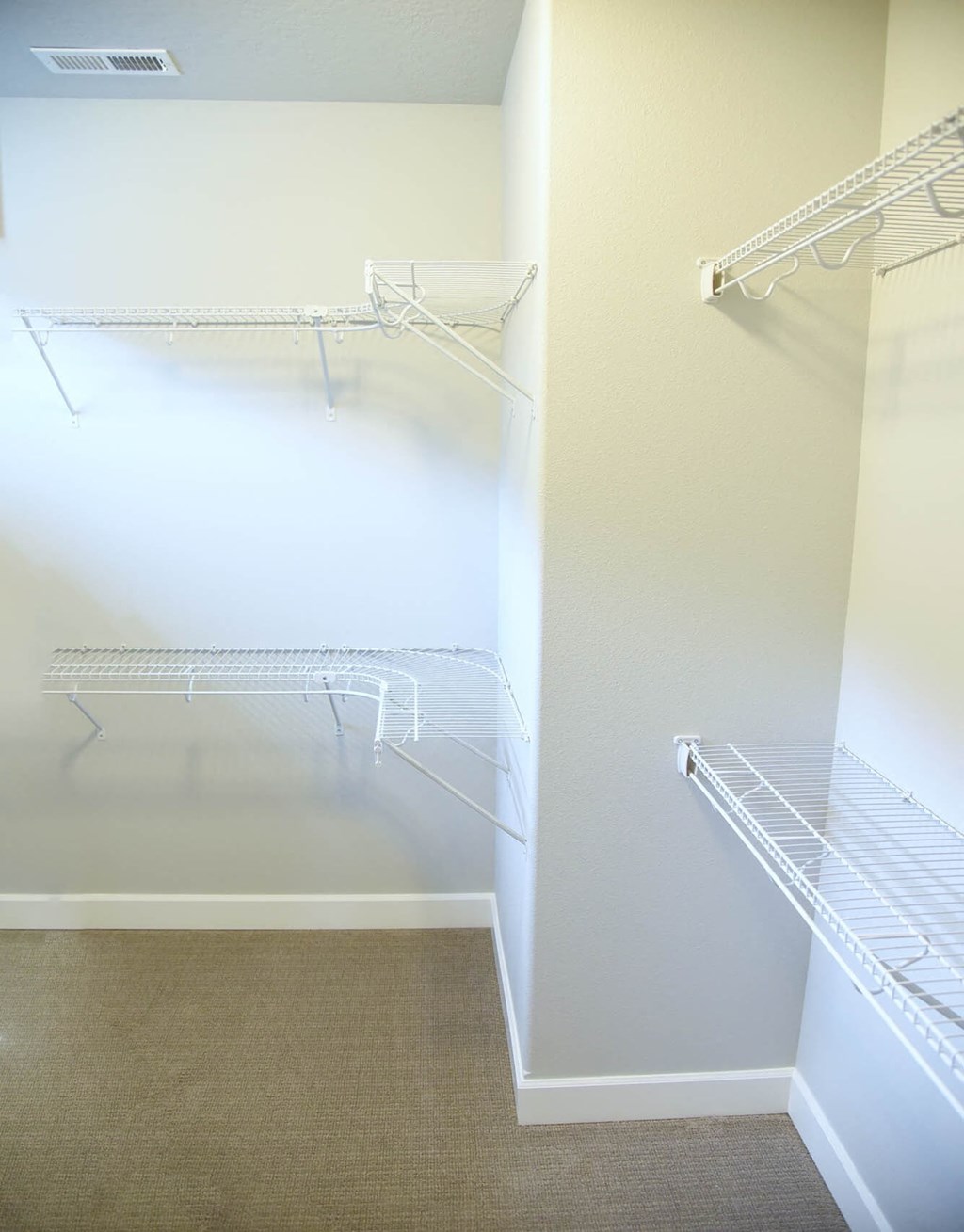a walk in closet with shelves and a mirrored closet door
