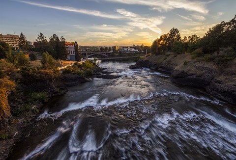 A river flows through a rocky landscape with a bridge in the background.