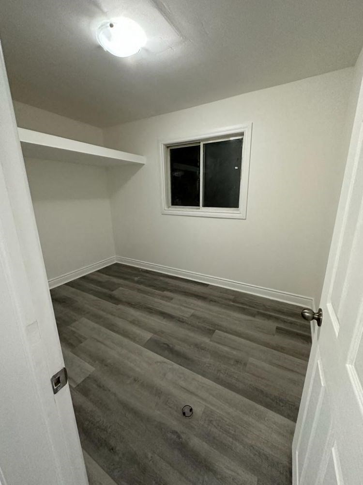 a empty room with wooden floors and a window