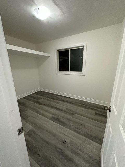 a empty room with wooden floors and a window