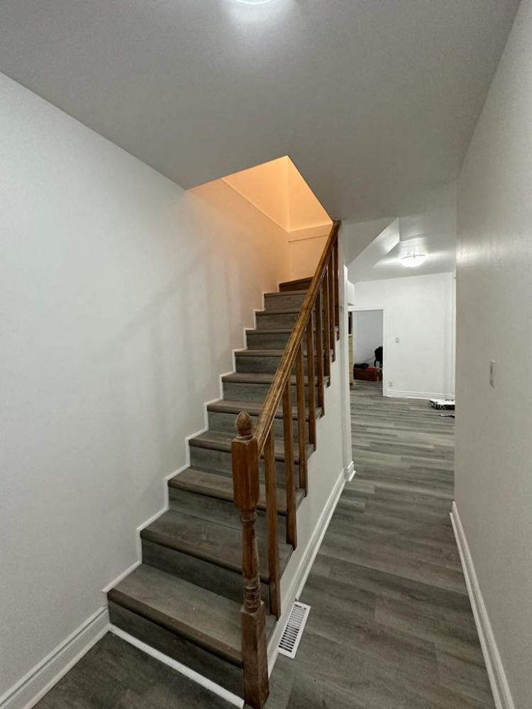 a staircase in a home with white walls and wood floors