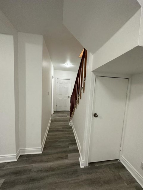 a hallway with a white door and a staircase     and a door