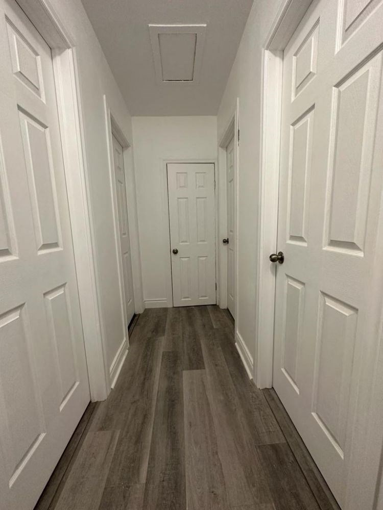 a hallway with wood floors and white doors