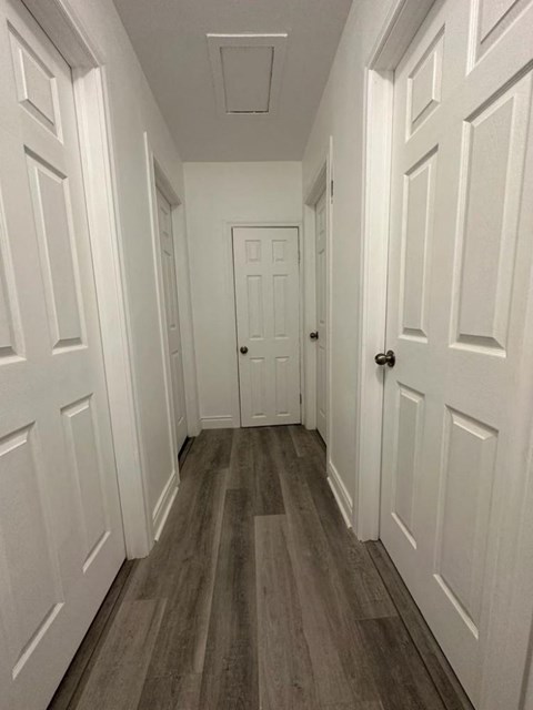 a hallway with wood floors and white doors
