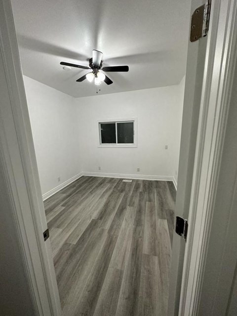 a room with wood floors and a ceiling fan