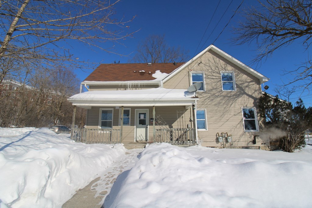 a house covered in snow on a sunny day