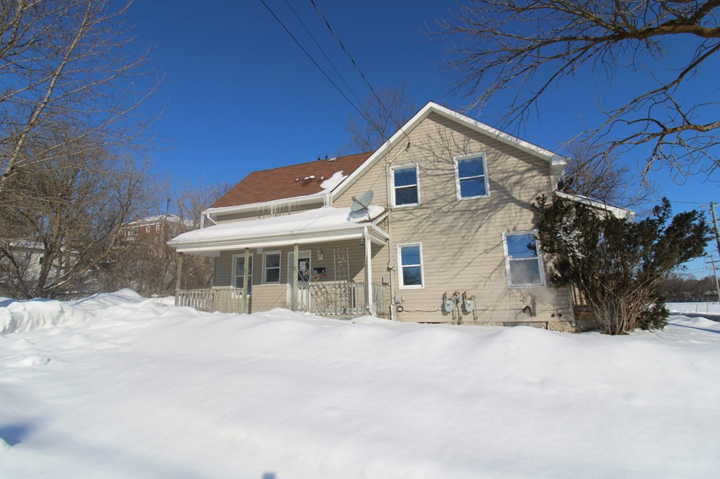 a house covered in snow on a sunny day