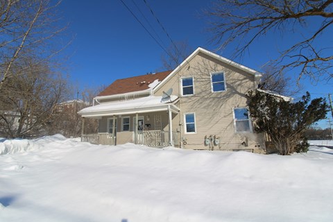 a house covered in snow on a sunny day