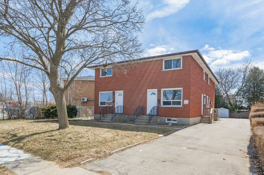 a red brick house with a sidewalk in front of it