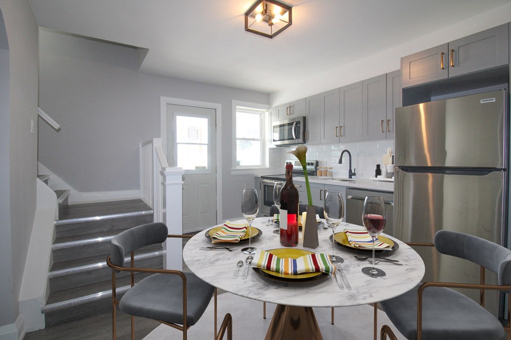 a kitchen and dining area with a table and chairs and a refrigerator