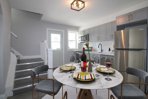 a kitchen and dining area with a table and chairs and a refrigerator