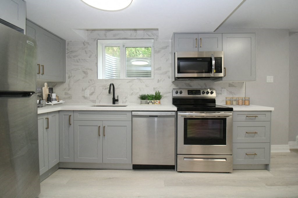 a white kitchen with stainless steel appliances and white cabinets