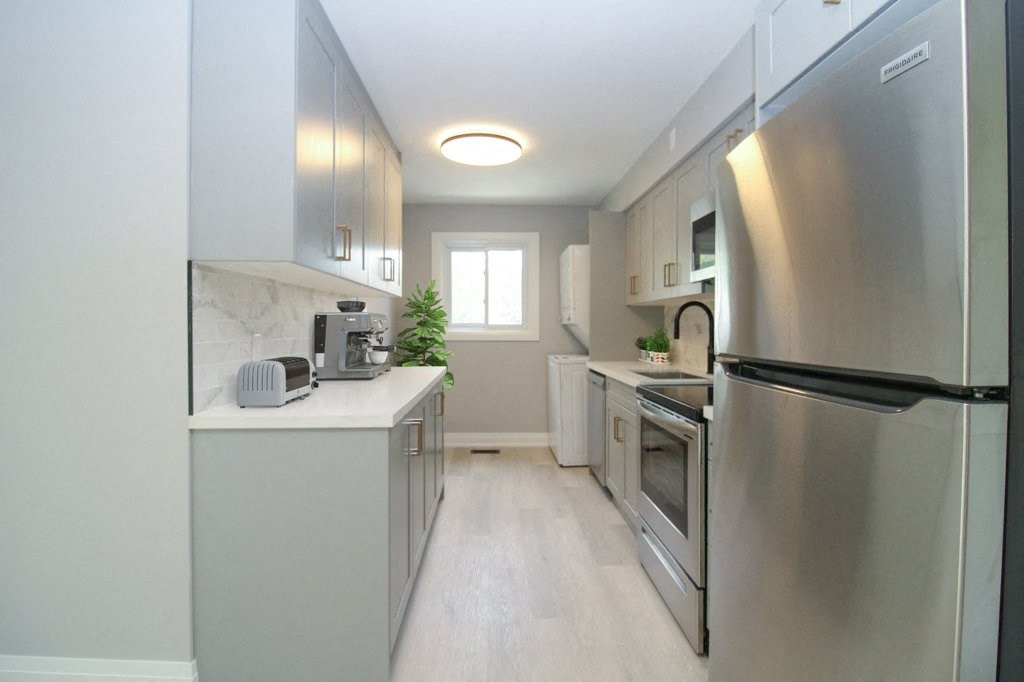 a renovated kitchen with stainless steel appliances and white counter tops