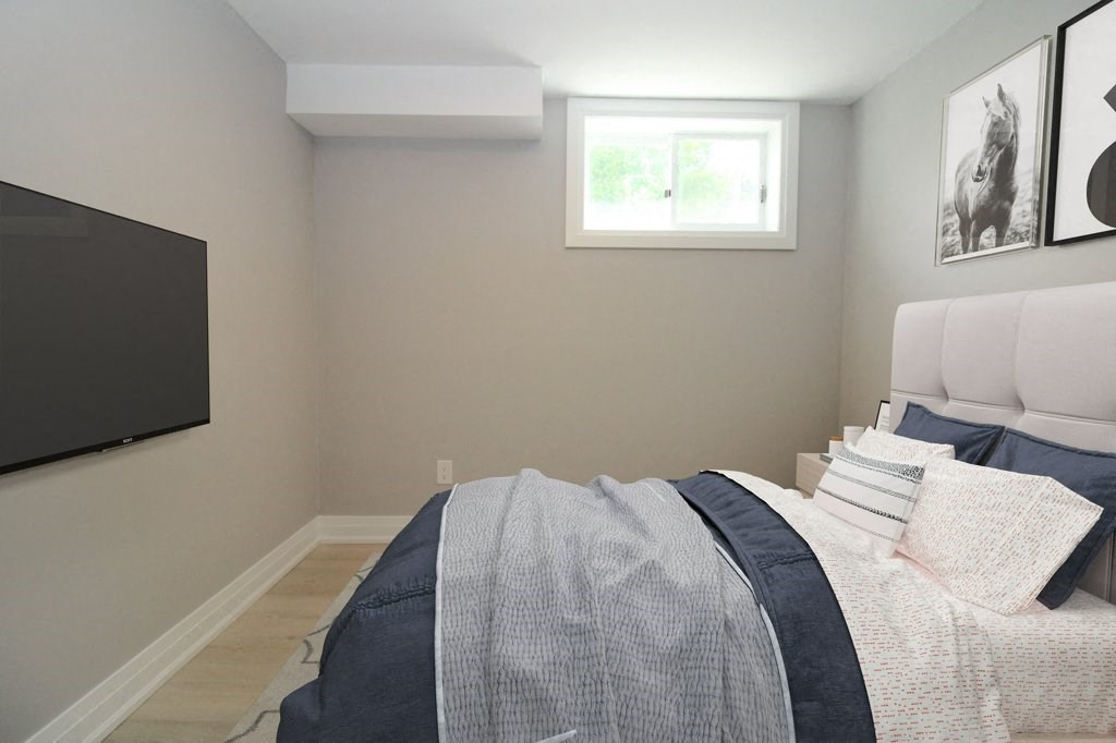 a bedroom with a bed and a tv on the wall