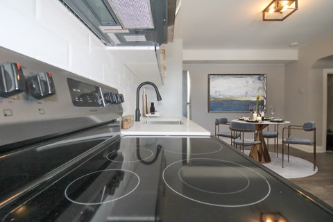 a kitchen with a stove and a sink and a dining table