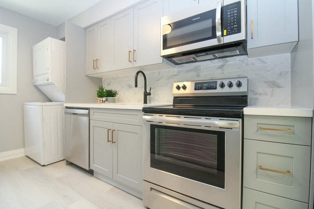 a white kitchen with stainless steel appliances and white cabinets