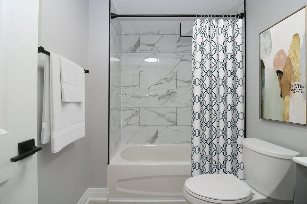 a bathroom with a shower and a toilet and a shower curtain