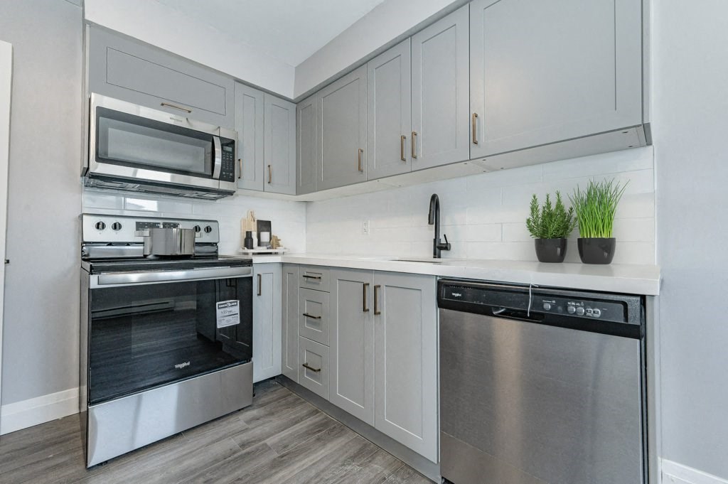 a kitchen with white cabinets and stainless steel appliances
