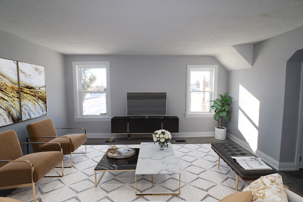 a living room with a couch and chairs and a television