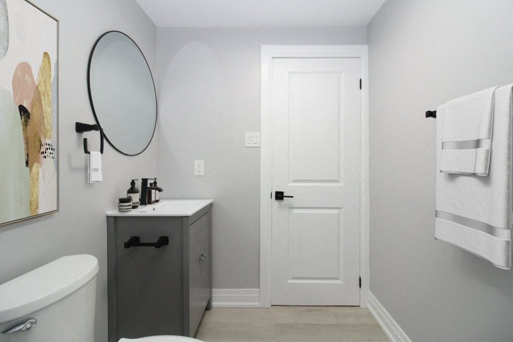 a small bathroom with a white door and a sink and toilet