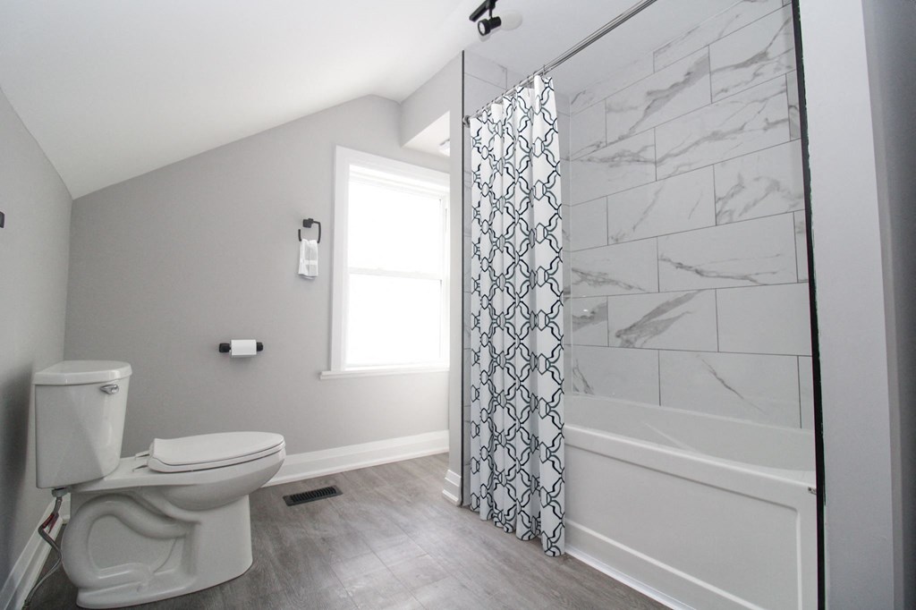 a bathroom with a toilet and a shower with a curtain