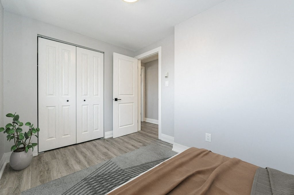 a bedroom with white doors and a bed and a door to a hallway