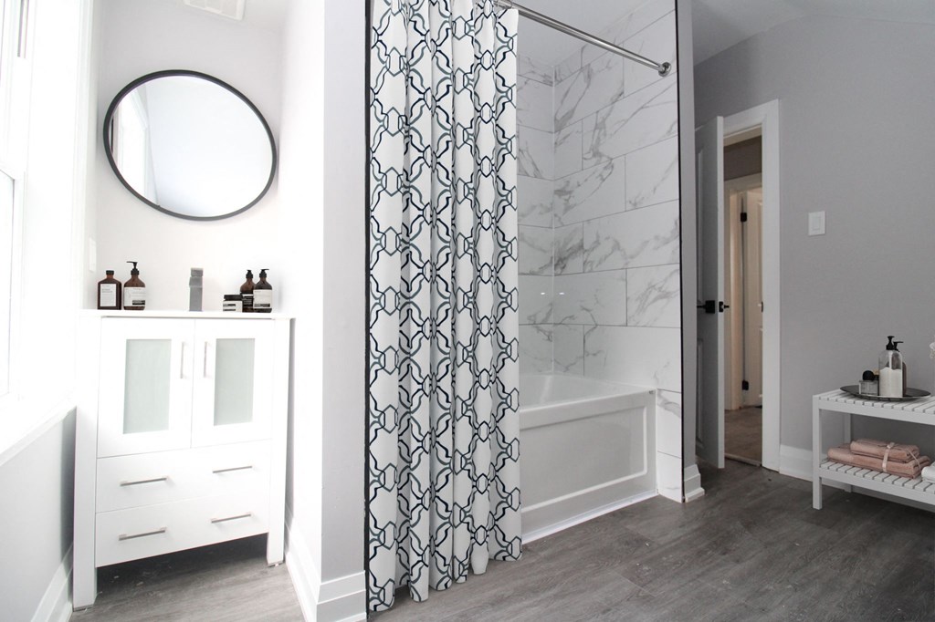 a bathroom with a shower curtain and a sink and a mirror