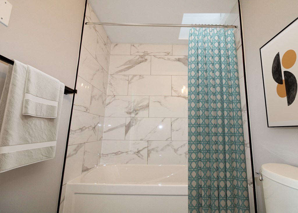 the bathroom has a tub and a shower and a toilet