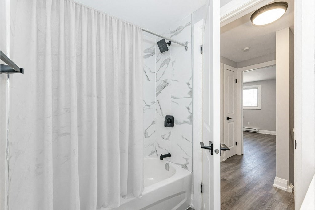 a white bathroom with a shower and a tub