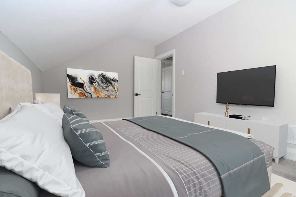 a bedroom with a bed and a tv on the wall