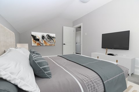 a bedroom with a bed and a tv on the wall