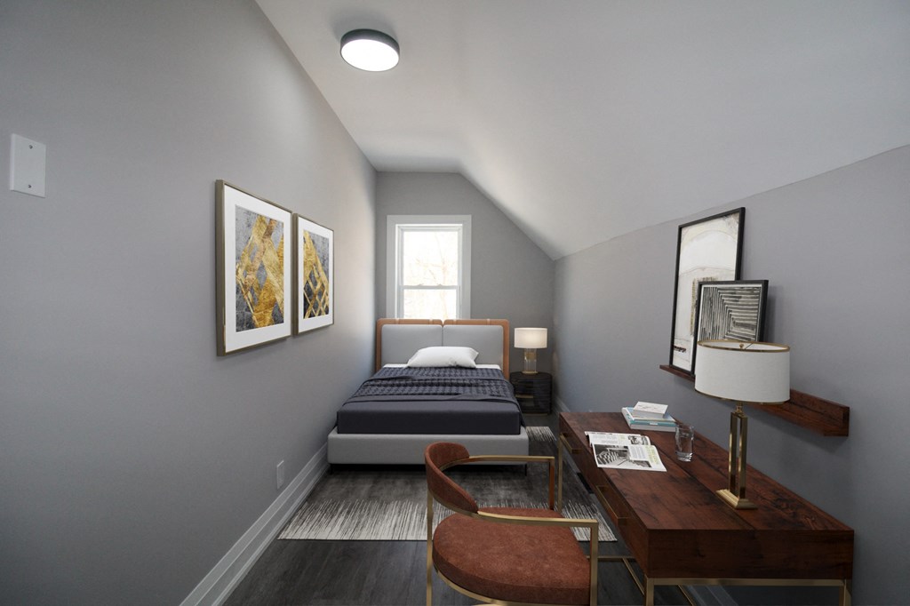 a bedroom with a bed and a desk in a small room