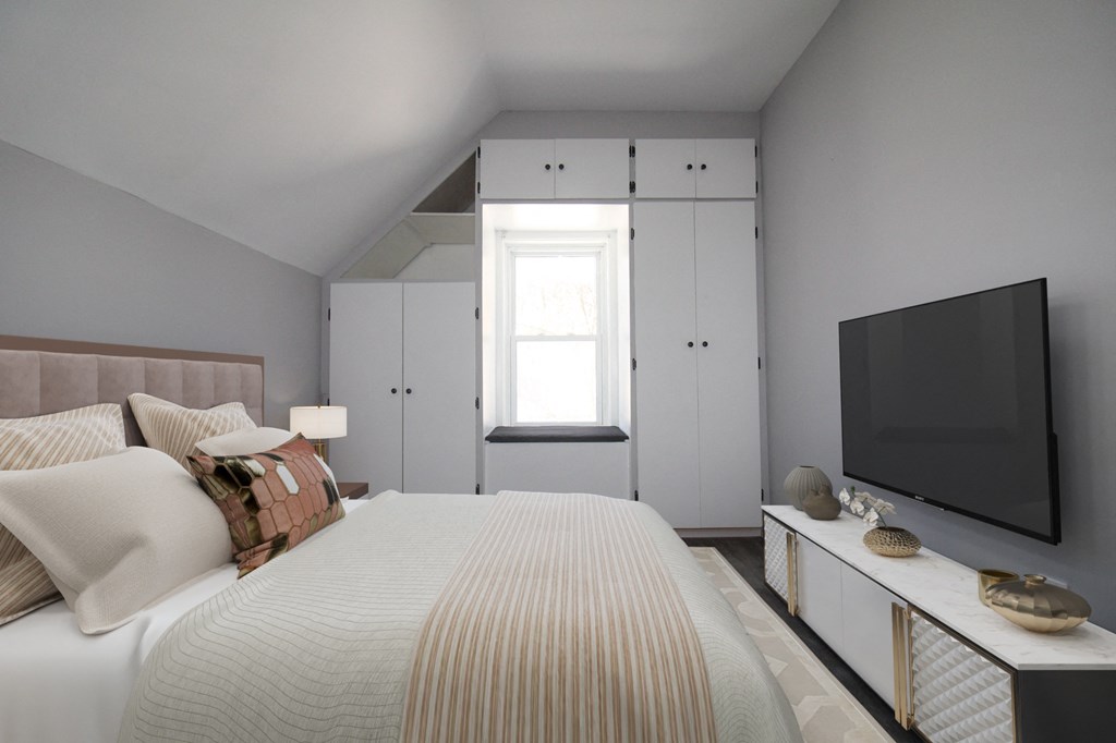 a bedroom with a large bed and a tv on the wall