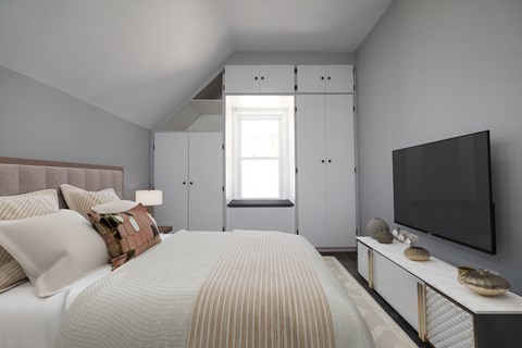 a bedroom with a large bed and a tv on the wall