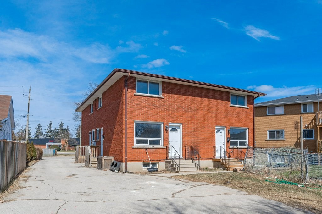 the front of a brick house with a sidewalk in front of it