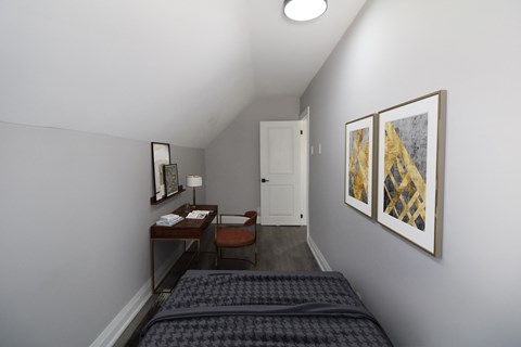 a small bedroom with a bed and a desk