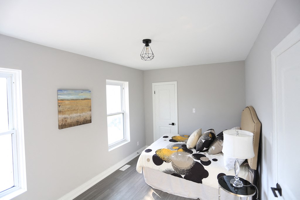 a bedroom with a bed and a table with pillows on it