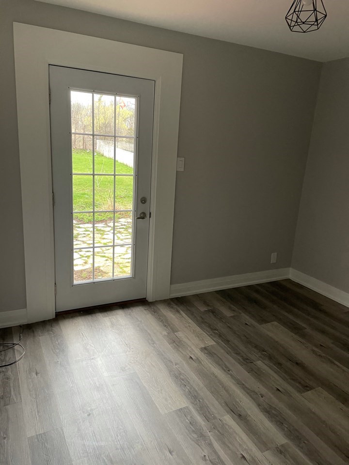 a room with wood floors and a door with a window