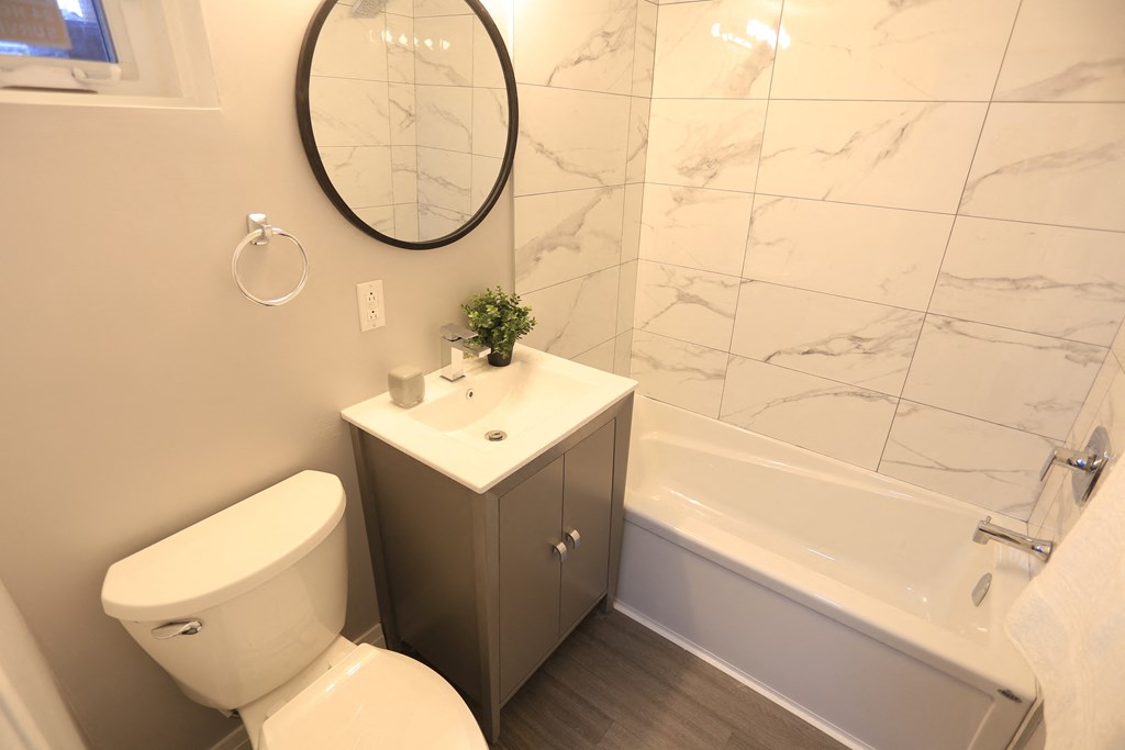 a bathroom with a toilet and a sink and a bath tub