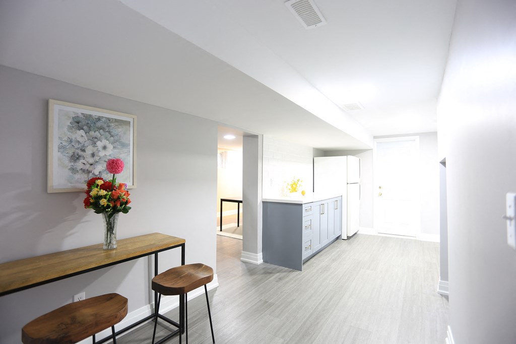 a living room with a table with two chairs and a vase of flowers
