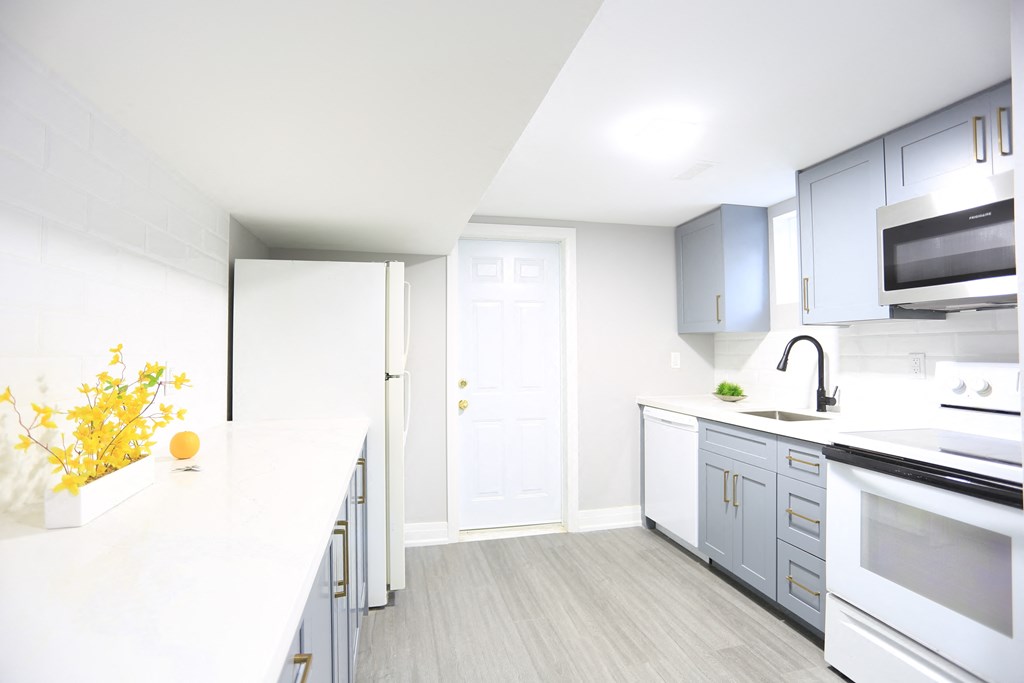 a modern kitchen with white countertops and blue cabinets